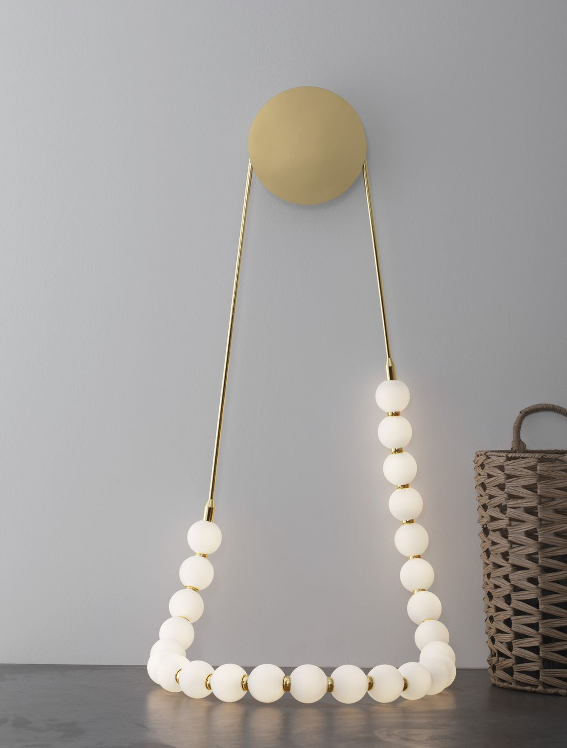 Mise en ambiance du luminaire mural au-dessus d'une table sombre avec panier tressé