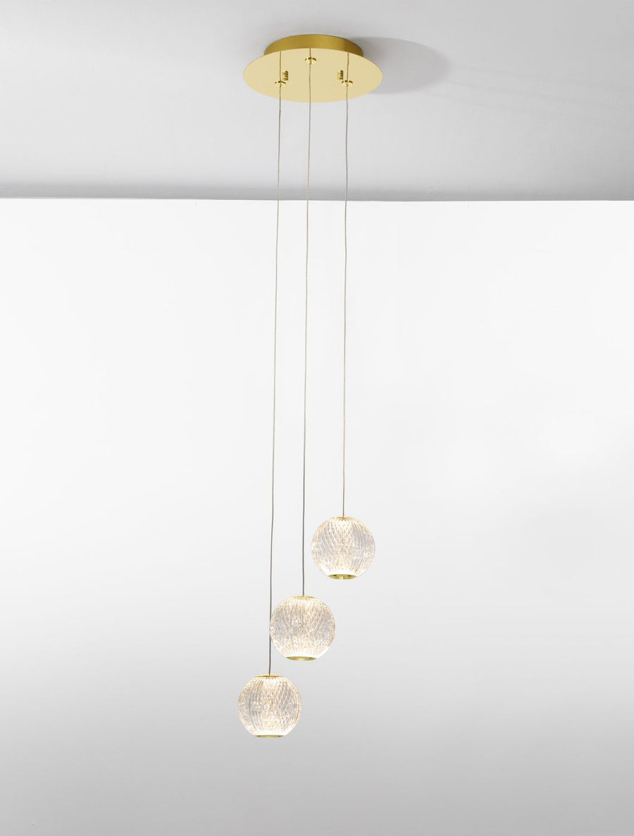 Même suspension allumée, lumière chaude diffusée par les globes décalés