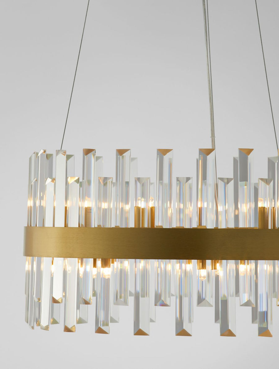 Détail rapproché du bandeau doré et des gouttes de cristal sur fond clair