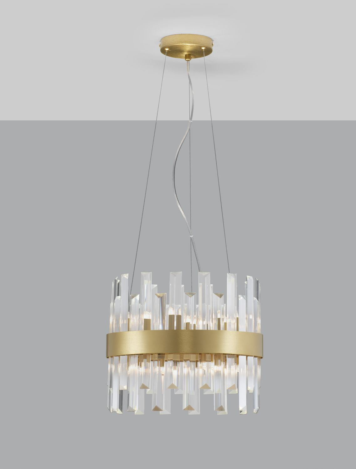 Suspension allumée sur fond gris, halo lumineux diffusé à travers les prismes de cristal