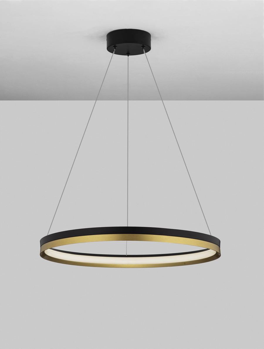 Suspension allumée sous plafond, halo lumineux blanc sous l'anneau noir et doré.