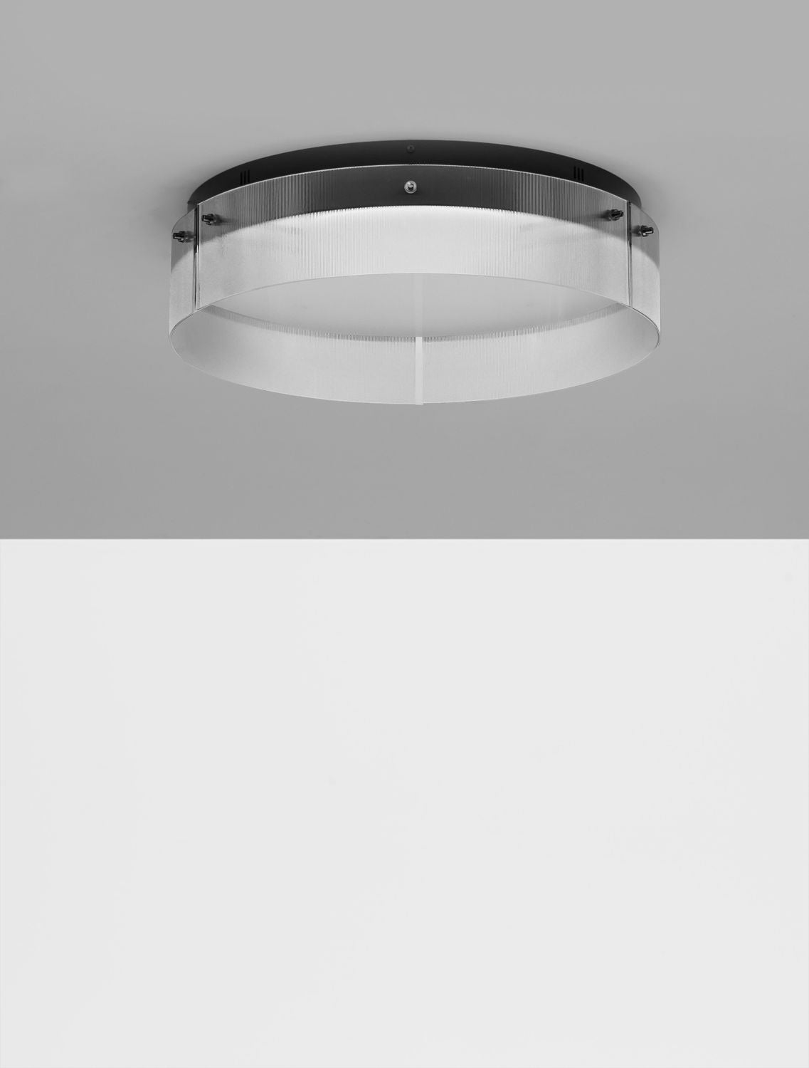Plafonnier éteint fixé au plafond gris, vu de trois quarts légèrement dessous