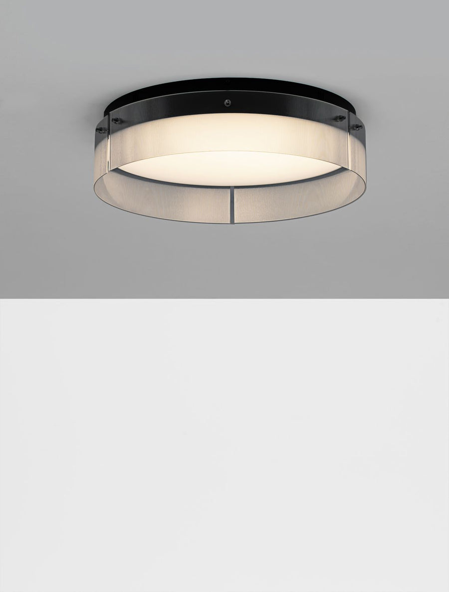 Plafonnier allumé diffusant une lumière blanche uniforme sous un plafond gris