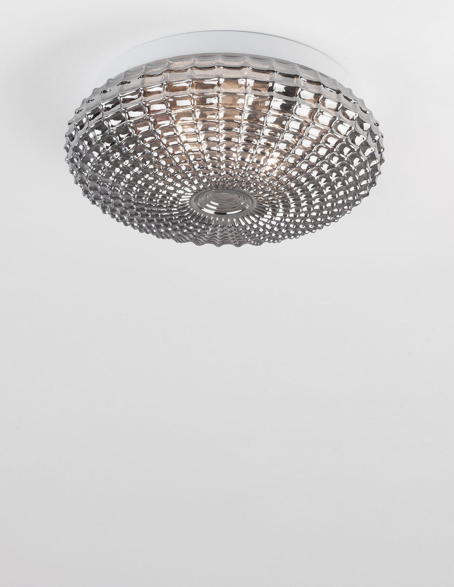 Plafonnier allumé diffusant une lumière chaude dans une pièce blanche