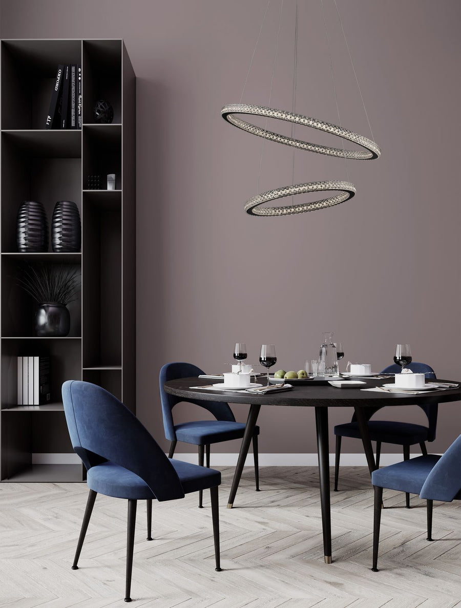 Suspension double anneau allumée au-dessus d'une table ronde en salle à manger