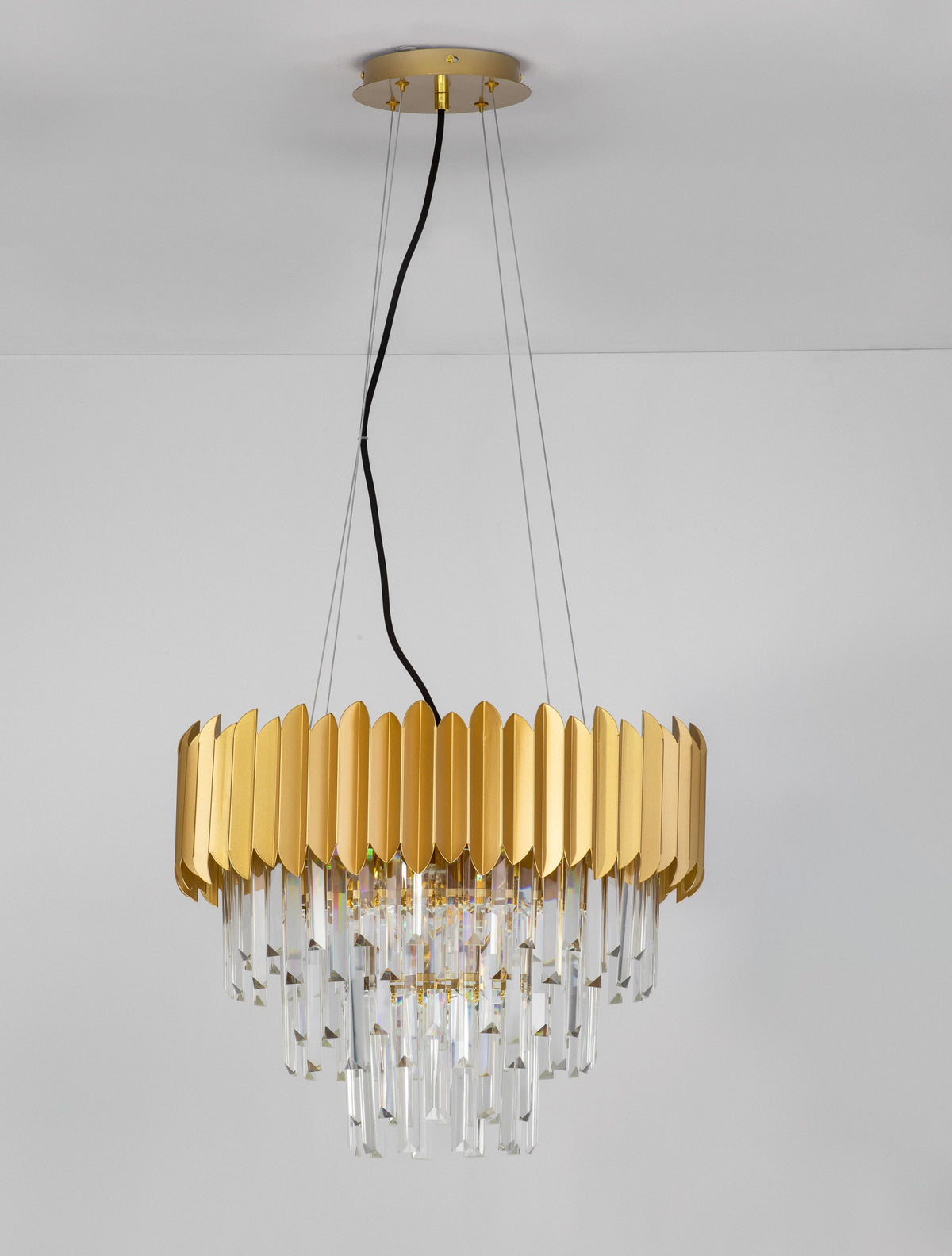 Luminaire suspendu au plafond sur fond gris, avec câble noir et cristaux.