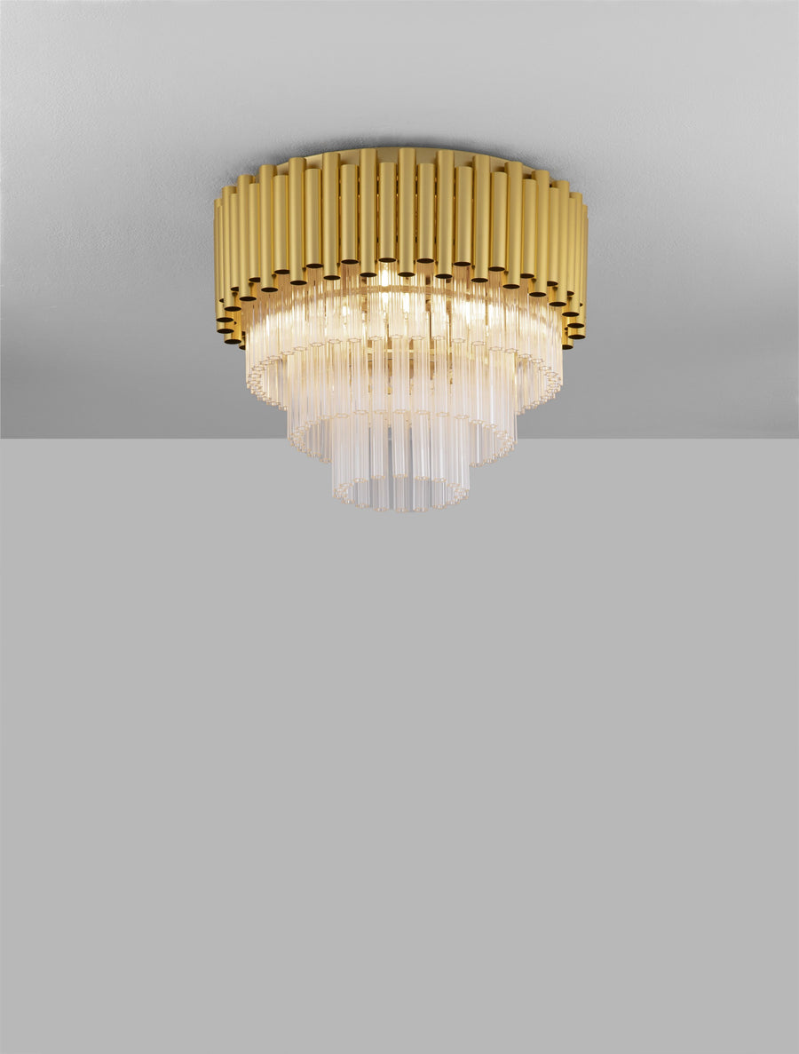 Plafonnier doré et cristal installé au plafond, lumière allumée, fond gris