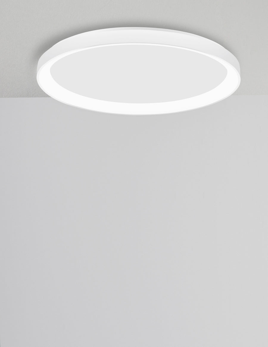 Plafonnier rond blanc vu de face, fixé contre le plafond gris clair.