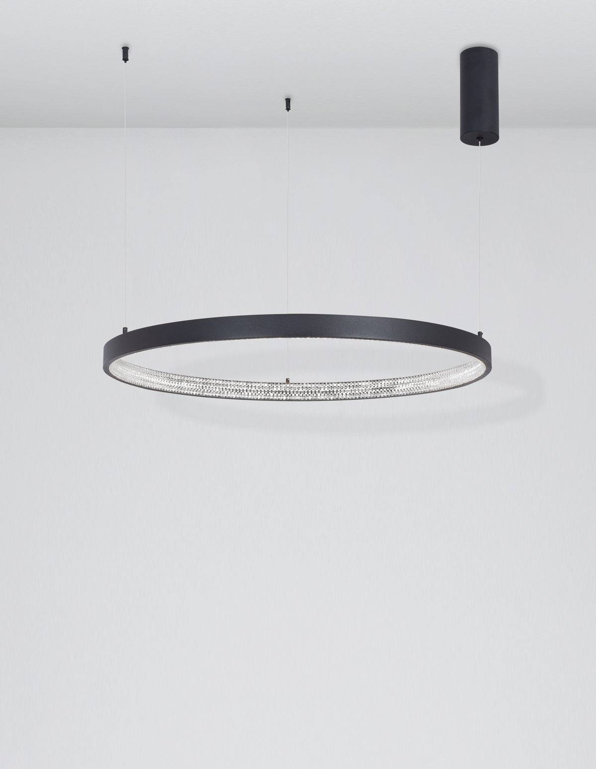 Mise en ambiance sous plafond blanc, suspension ronde allumée et câbles fins
