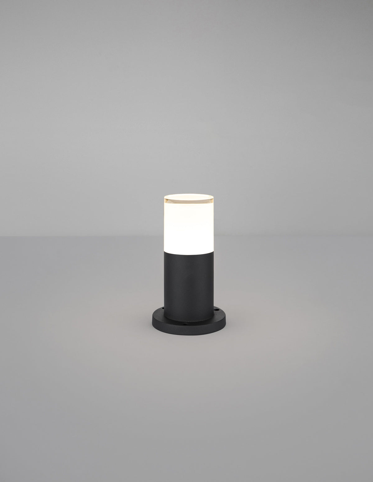 Borne extérieure allumée, diffuseur blanc lumineux au-dessus du socle noir.