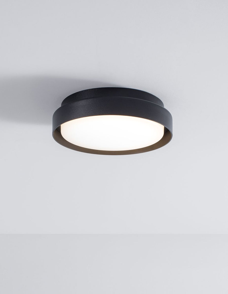 Même luminaire allumé, diffusant une lumière chaude sous un plafond blanc