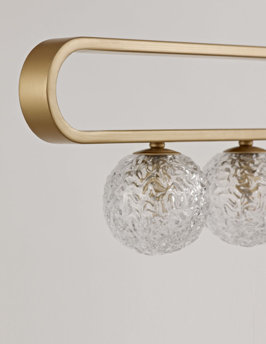 Détail de la structure en laiton brossé et des globes en verre martelé transparent