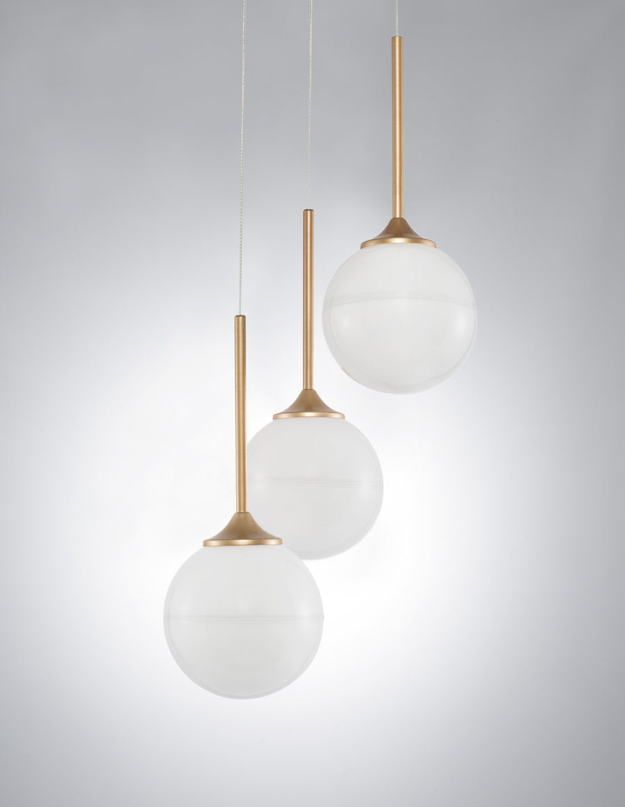 Gros plan sur les trois globes en verre blanc et leurs fines tiges dorées.
