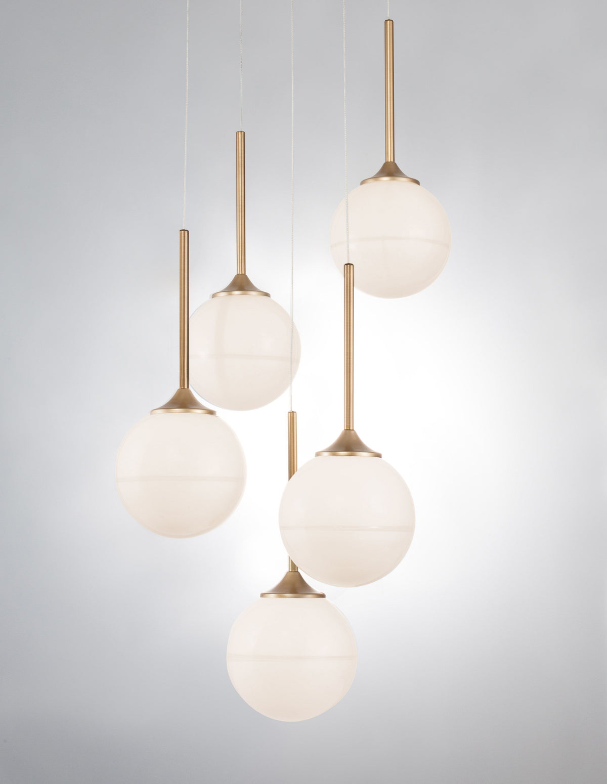 Gros plan sur les globes allumés diffusant une lumière chaude et les tiges dorées.