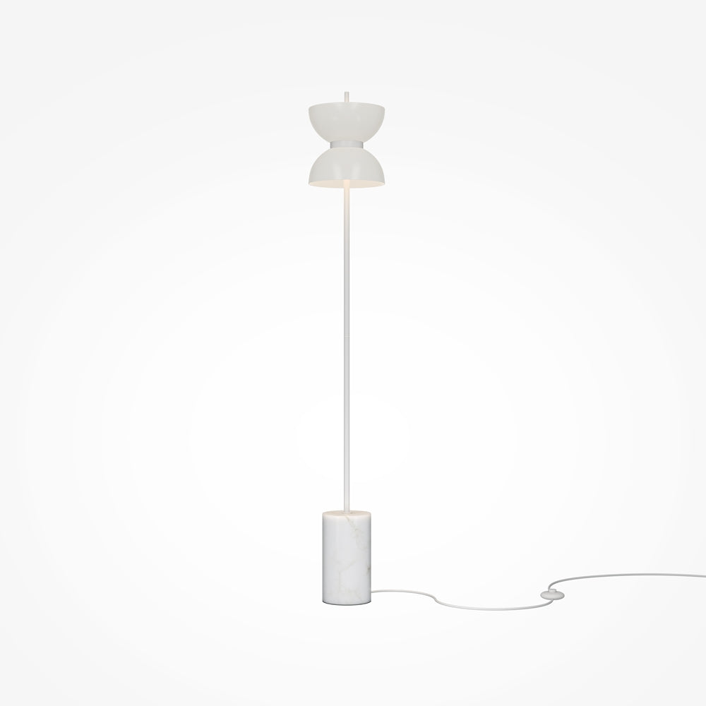 Lampe sur socle cylindrique de marbre blanc, câble et fiche visibles au sol.
