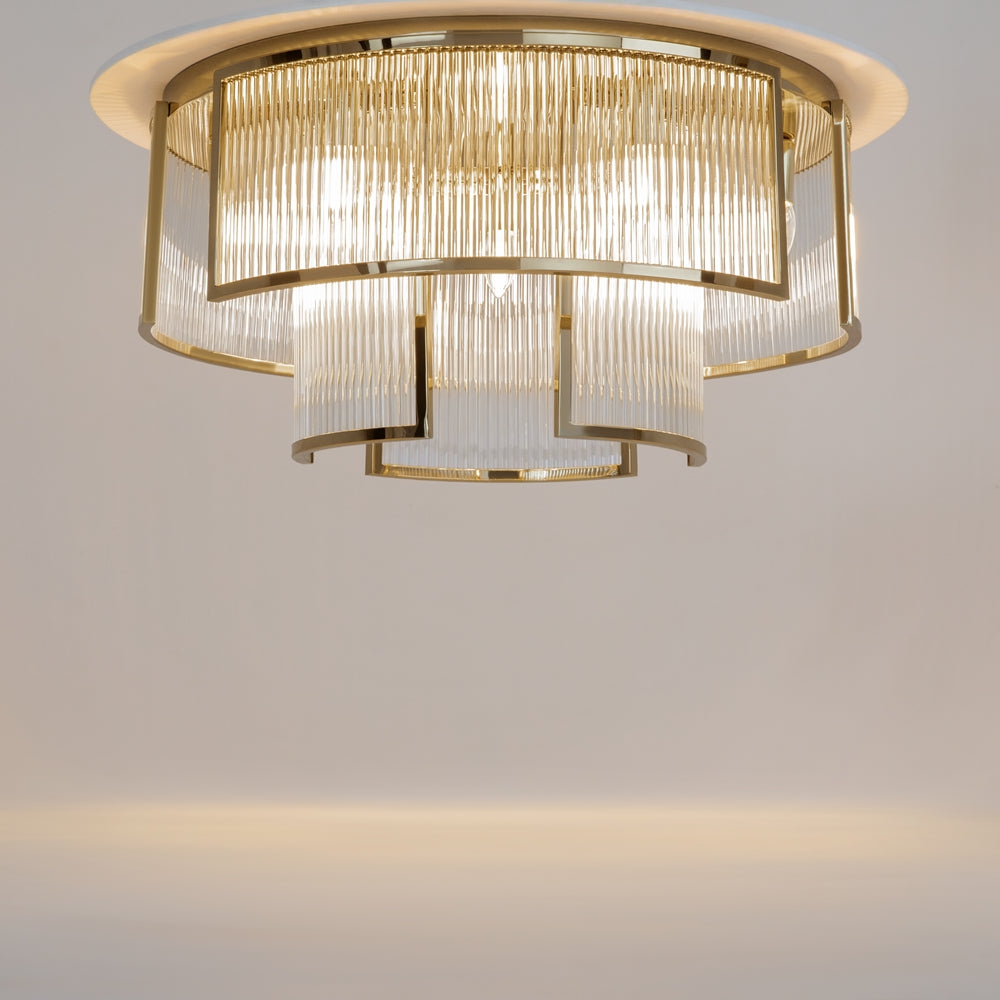 Luminaire allumé sous plafond, halo doré diffusé par les abat-jours cylindriques en verre rainuré