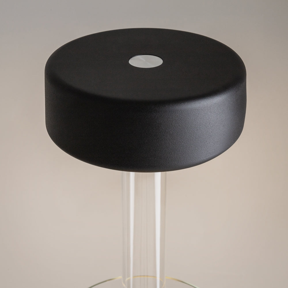 Détail du diffuseur noir mat et de son bouton central translucide en gros plan.