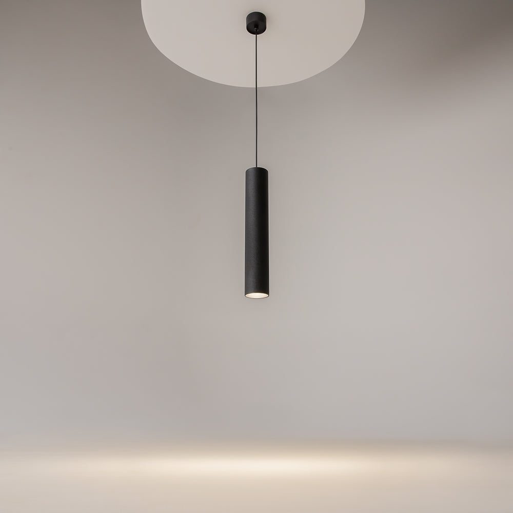 Mise en ambiance : le luminaire noir éclaire le mur et diffuse un halo.