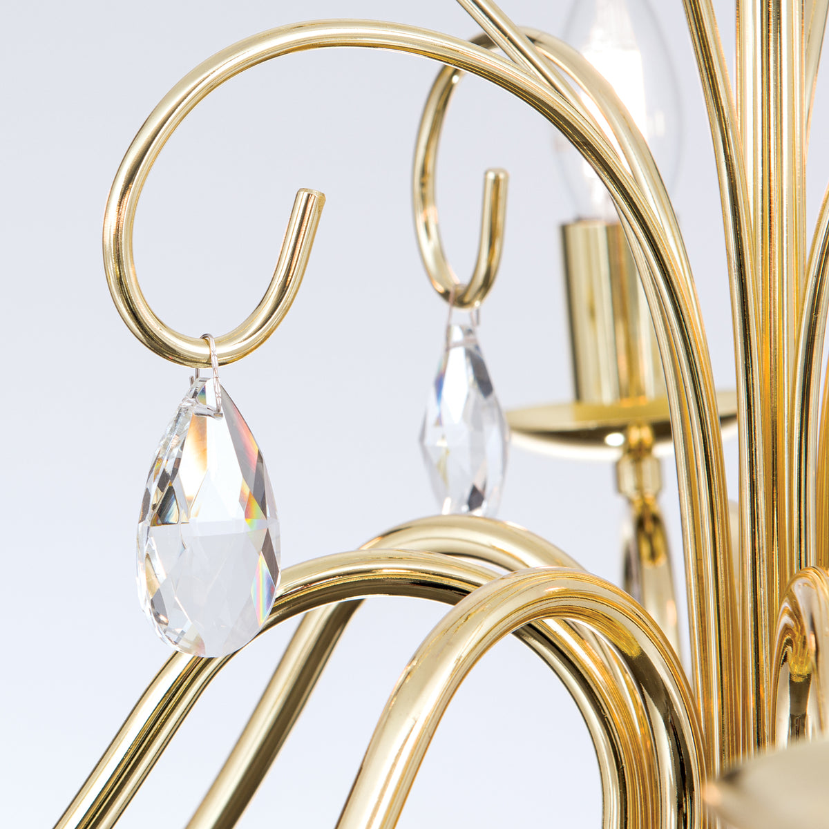 Gros plan sur les courbes dorées et les gouttes de cristal suspendues
