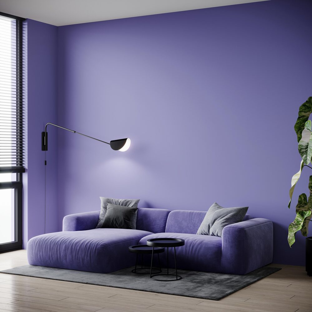Mise en ambiance dans un salon violet, l'applique éclaire le mur