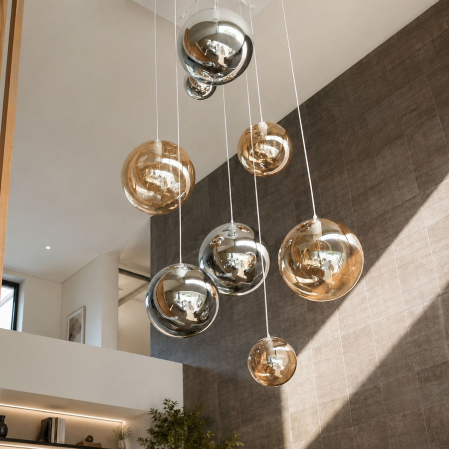 Vue rapprochée de globes en verre aux teintes ambre et claires sous câbles blancs.