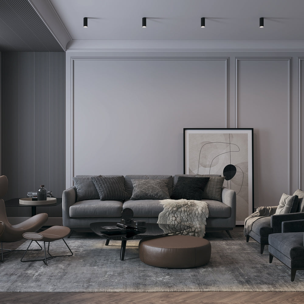 Mise en ambiance d'un salon moderne avec quatre spots noirs alignés au plafond