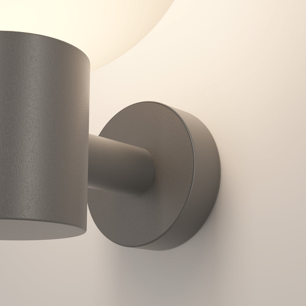 Vue rapprochée du bras cylindrique et du socle rond fixé au mur.