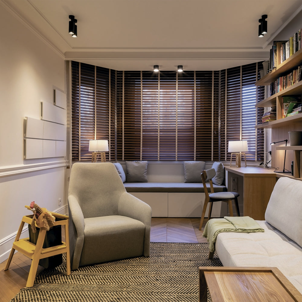 Mise en ambiance dans un salon avec plusieurs spots noirs au plafond