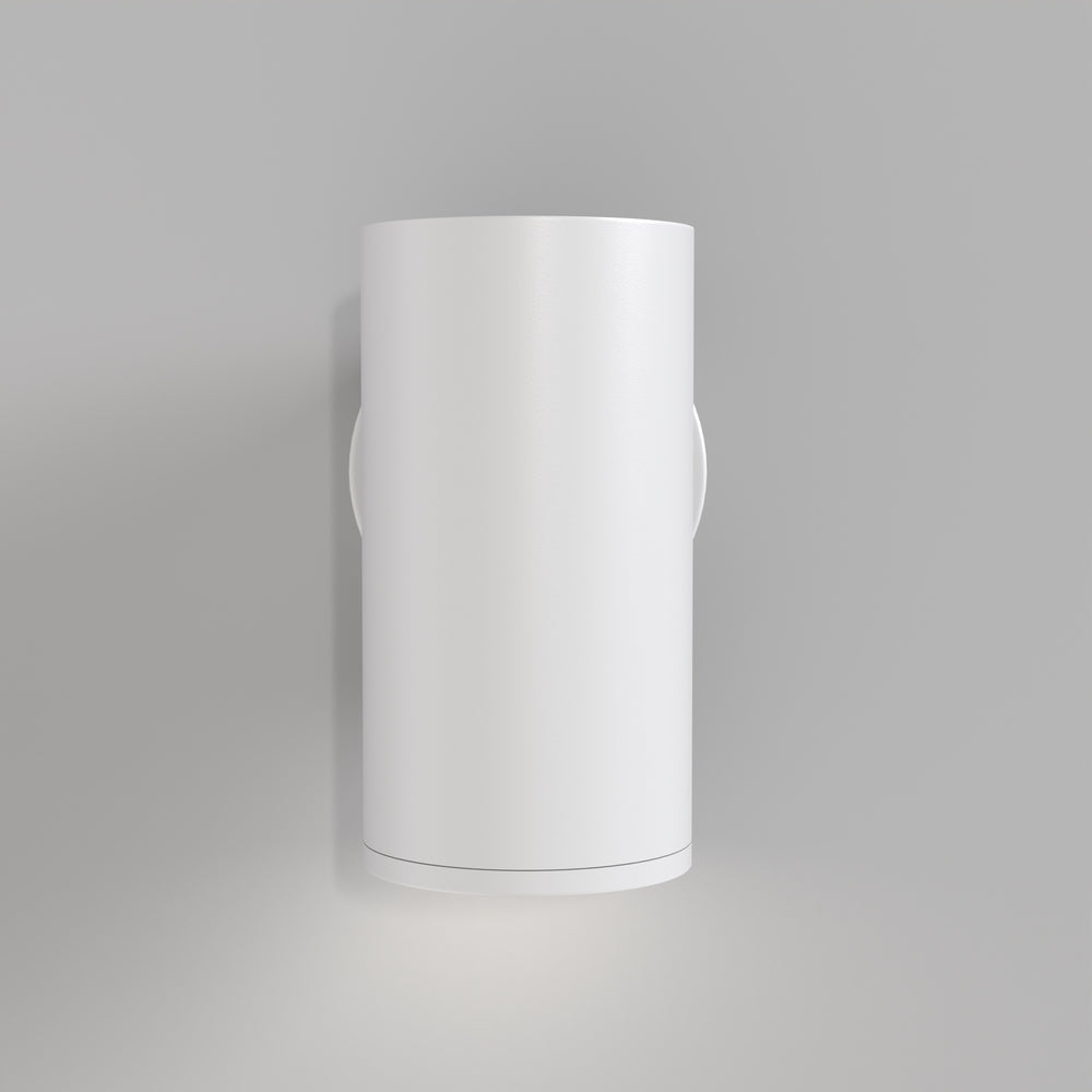 Applique blanche fixée sur un mur gris diffusant la lumière vers le bas
