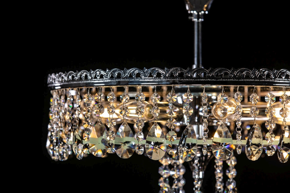 Détail de la bague métallique ornée et des chaînettes de cristal sur le pourtour.