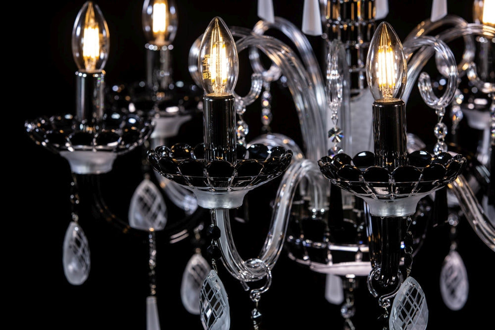 Détail rapproché des ampoules allumées et coupelles noires sur fond sombre