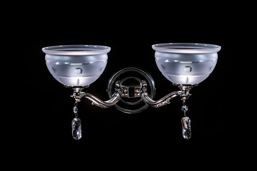 Même applique vue de face, verre dépoli ajouré, bras incurvés nickelés, gouttes de cristal suspendues.