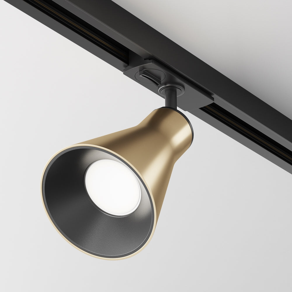 Spot doré sur rail noir vu de trois quarts, fond de plafond gris