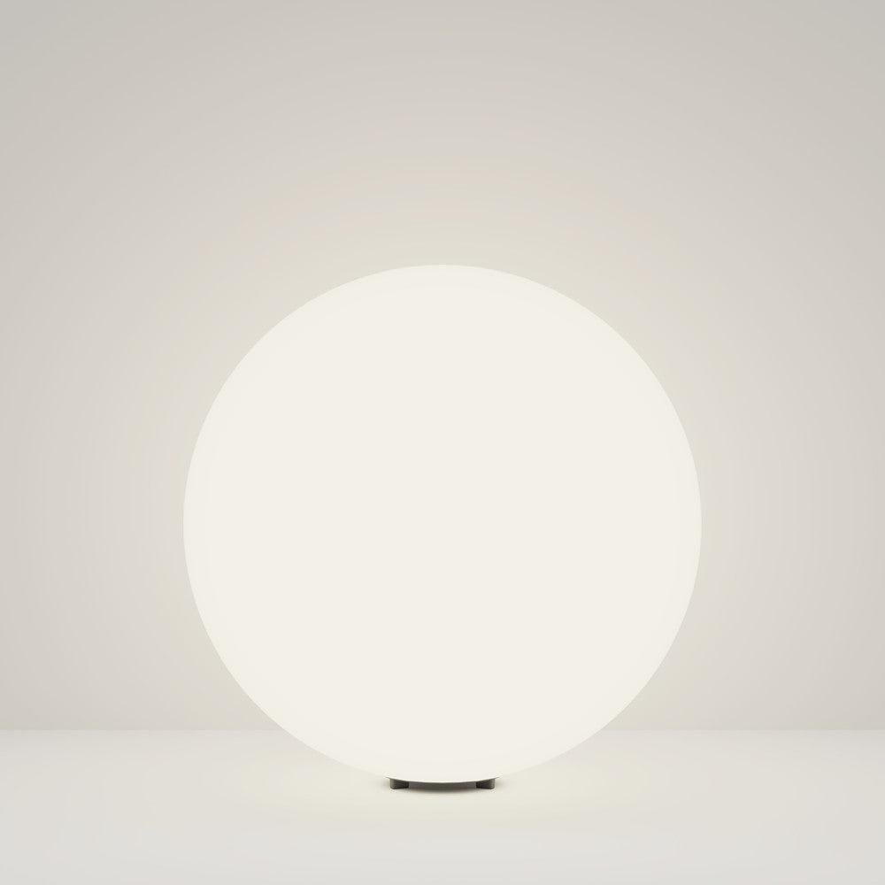 Luminaire sphérique ivoire de face, éclairé sur fond neutre clair