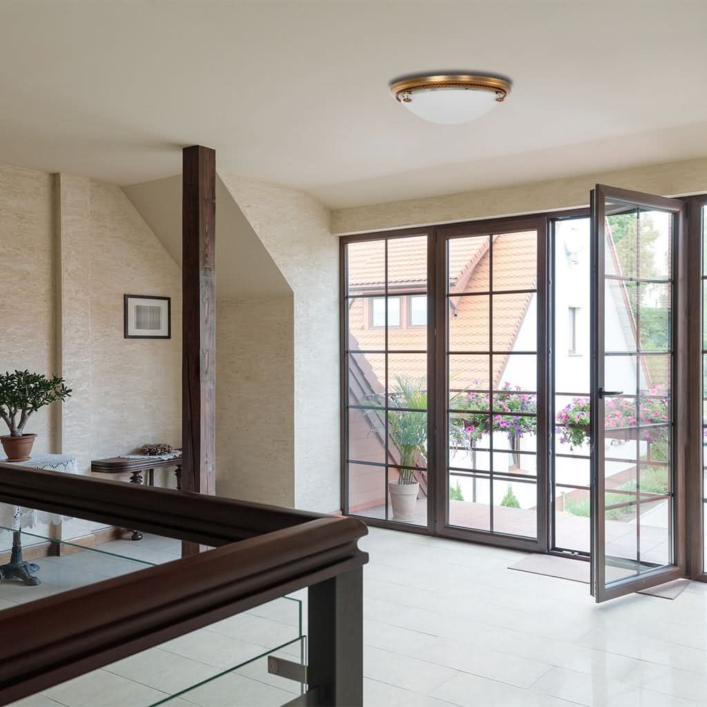 Luminaire fixé au plafond devant une baie vitrée ouverte, intérieur clair