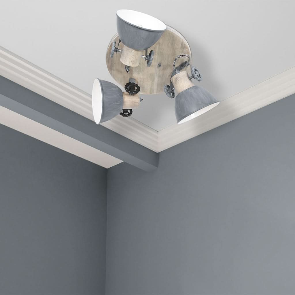 Plafonnier installé au plafond dans un coin, près de moulures blanches et murs gris.