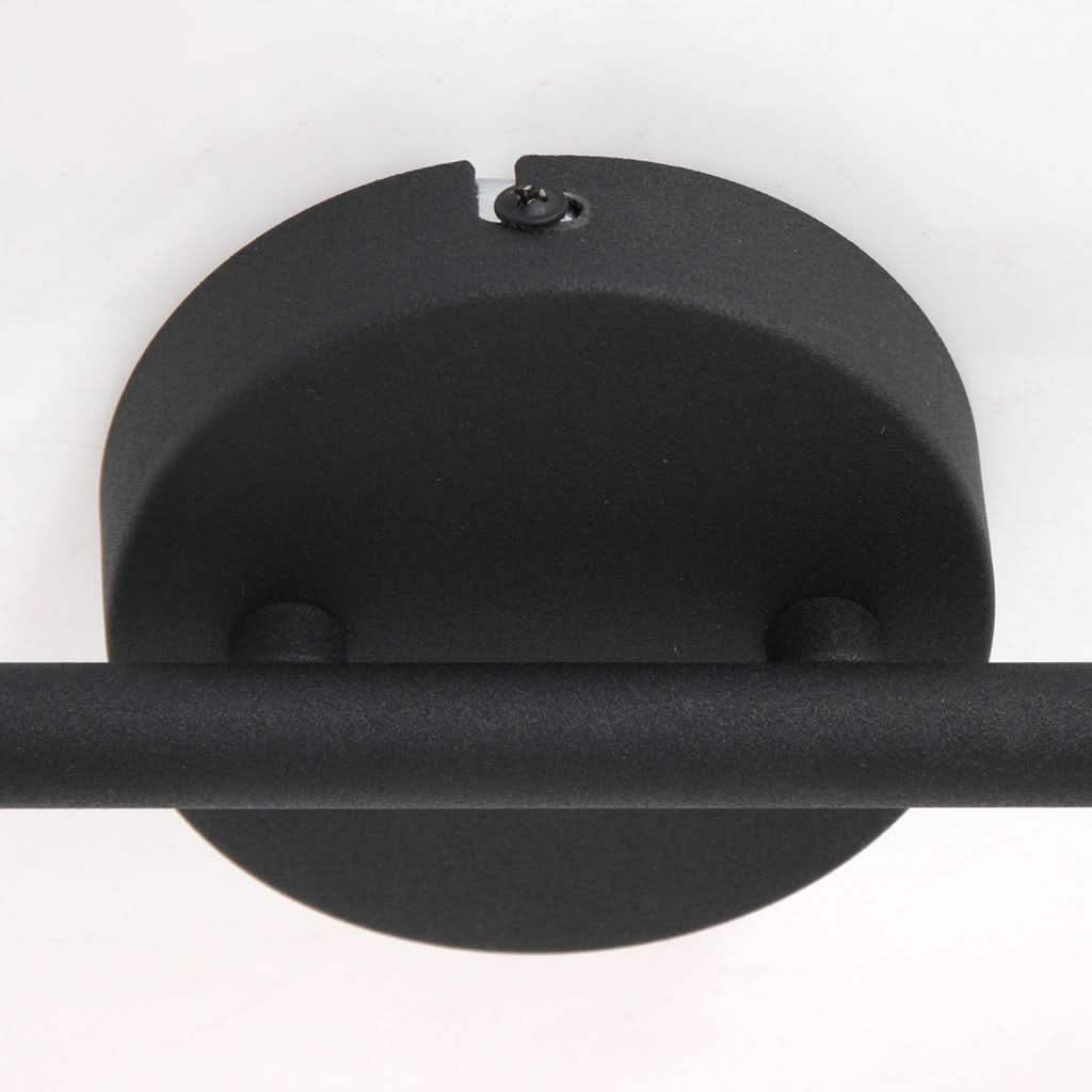 Détail de la base ronde noire fixée au plafond, avec vis apparente et barre traversante.