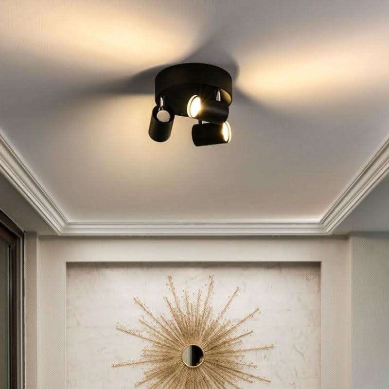 Version noire du luminaire au plafond, éclairant un miroir mural en forme de soleil