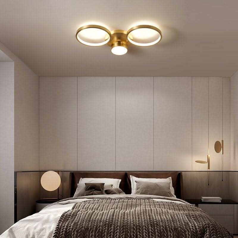 Vue de face du luminaire à deux cercles dorés fixé au plafond blanc