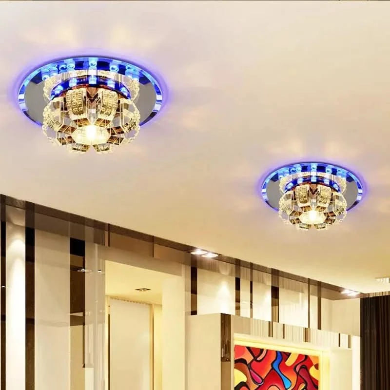 Deux plafonniers cristal allumés au plafond d'un intérieur contemporain, halo bleu.
