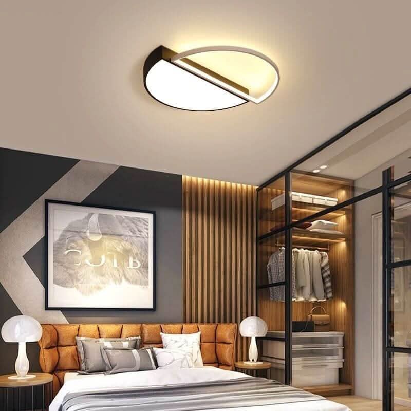 Ambiance nocturne, plafonnier allumé au-dessus d'un lit capitonné, cadre et dressing vitré