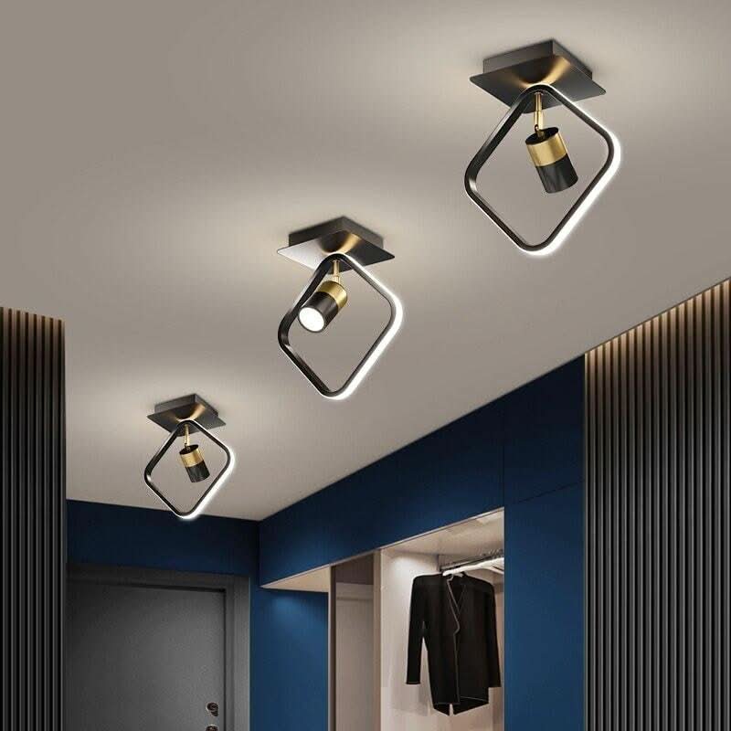 Trois luminaires carrés noirs avec spot doré orientable au-dessus d'un dressing bleu nuit