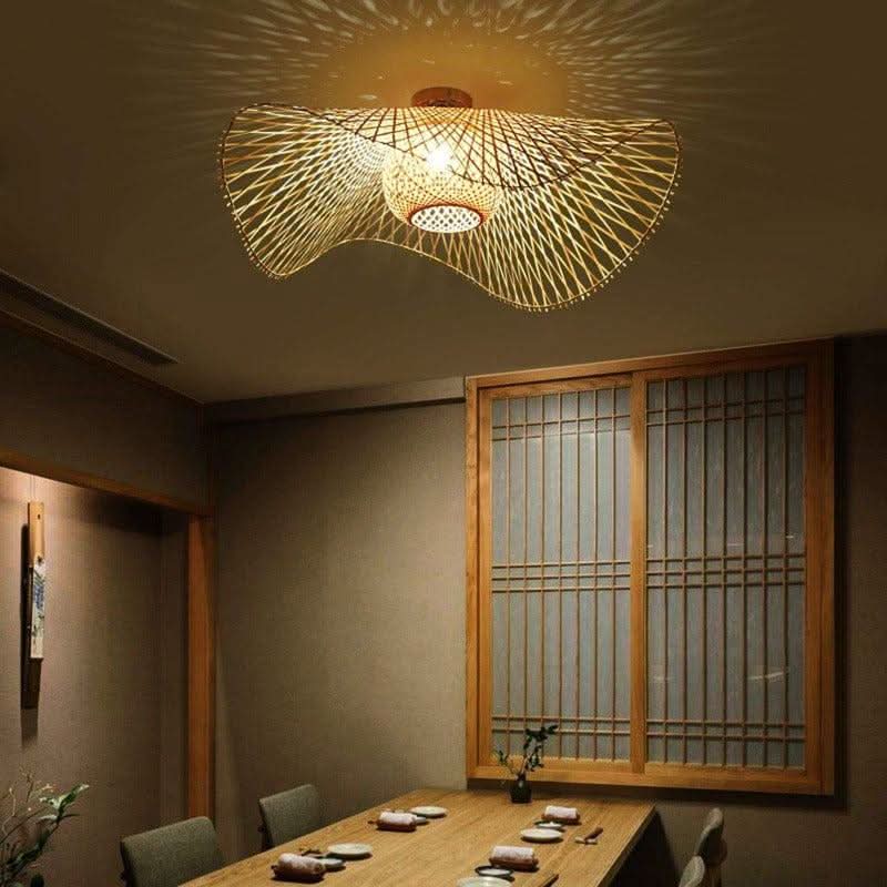 Vue plongeante du luminaire allumé au-dessus d'une table dressée dans un intérieur japonisant