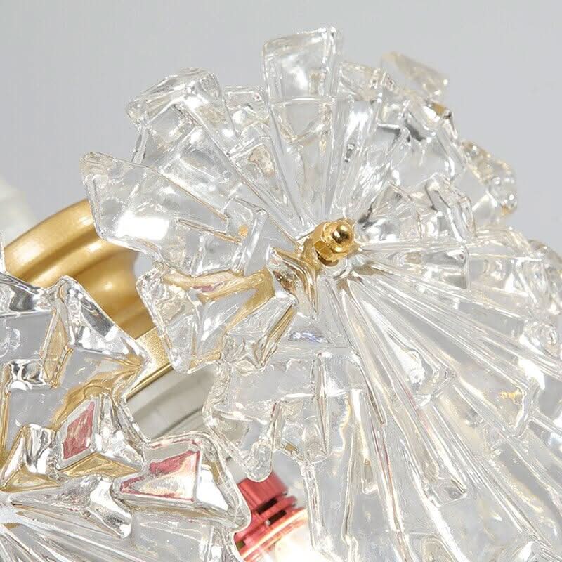 Gros plan sur les pétales de cristal et la monture dorée du luminaire
