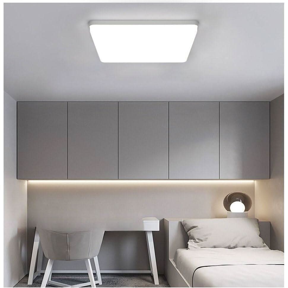 Chambre grise épurée, plafonnier carré blanc diffusant une lumière homogène au plafond