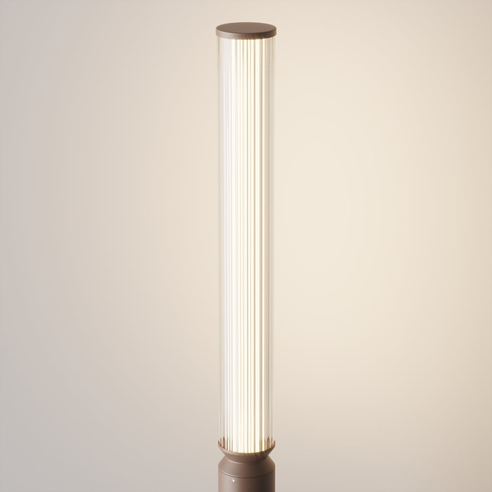 Gros plan sur le diffuseur cylindrique strié et sa lumière chaude, détail de la partie haute