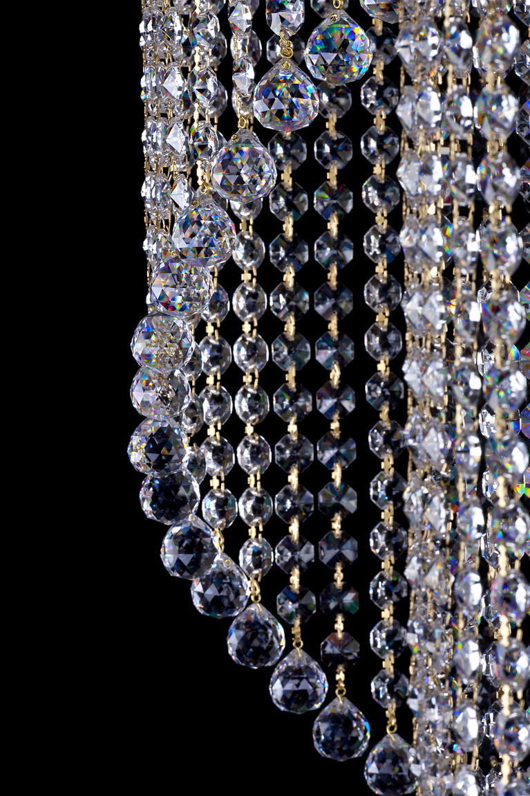 Gros plan sur les chaînes de cristaux taillés et leurs pendentifs lumineux en bas