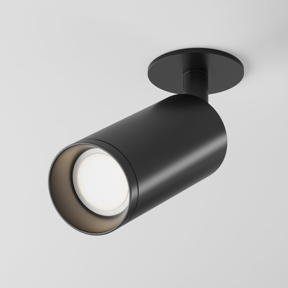 Projecteur noir orientable fixé au plafond, tête cylindrique inclinée vers le bas.