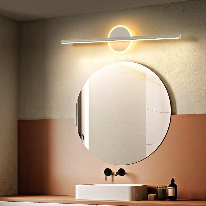 Ambiance chaleureuse : applique cercle allumée sur miroir rond et vasque en bois