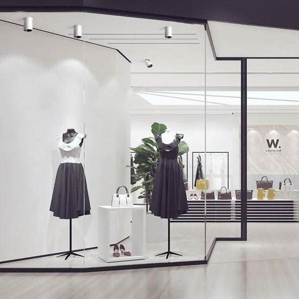 Spot blanc en situation dans une boutique, éclairant une vitrine avec mannequins et présentoirs.